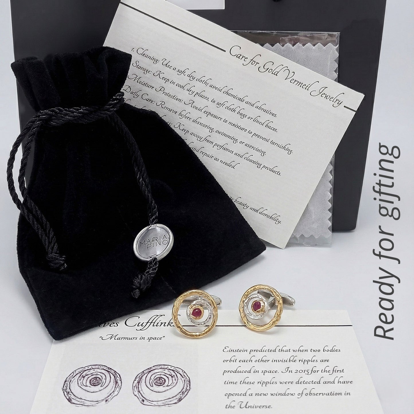 Gemelos de diseño escultórico en plata y oro vermeil con rubí presentados en packaging de joyería con bolsa y tarjeta