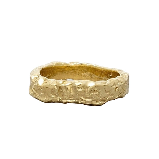 Anillo Superficie Solar de oro de 18 k con textura escultural sobre fondo gris