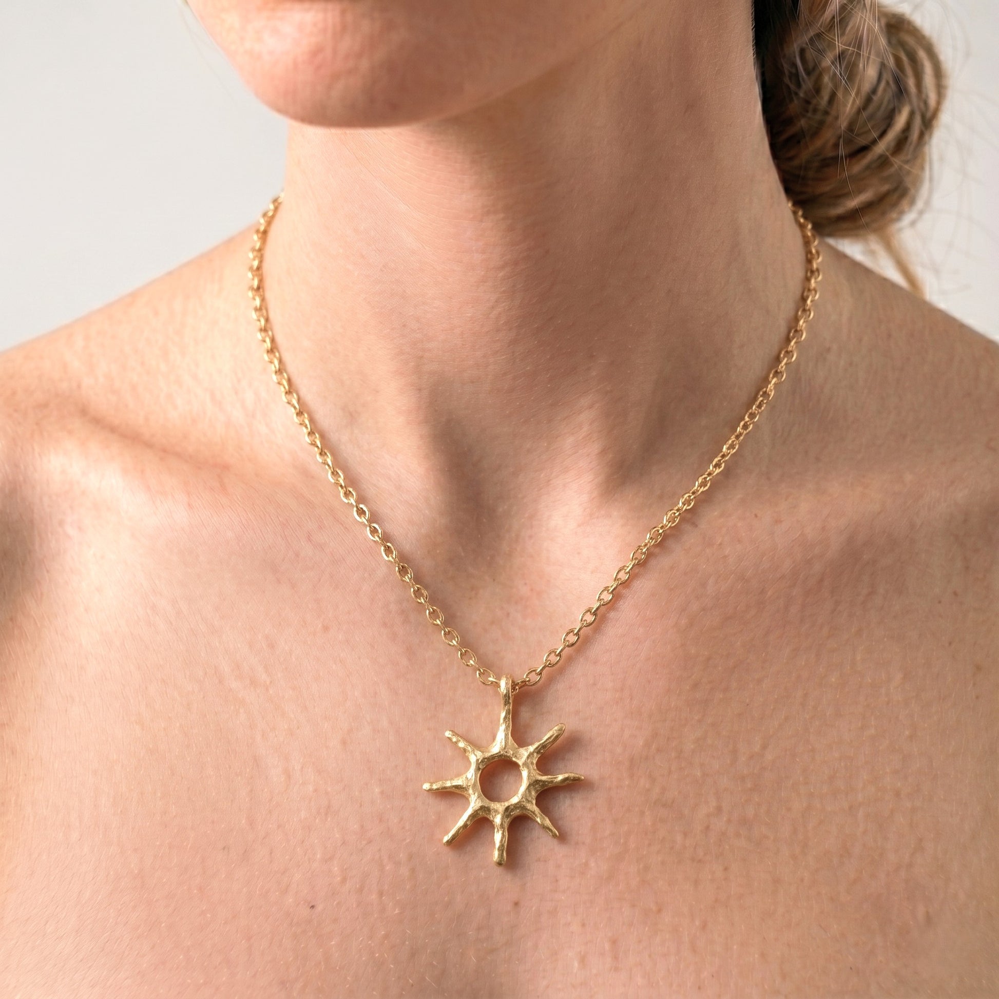 Primer plano de una mujer luciendo el colgante Estrella Polar de oro sobre el pecho, destacando su tamaño y cómo favorece al cuello.