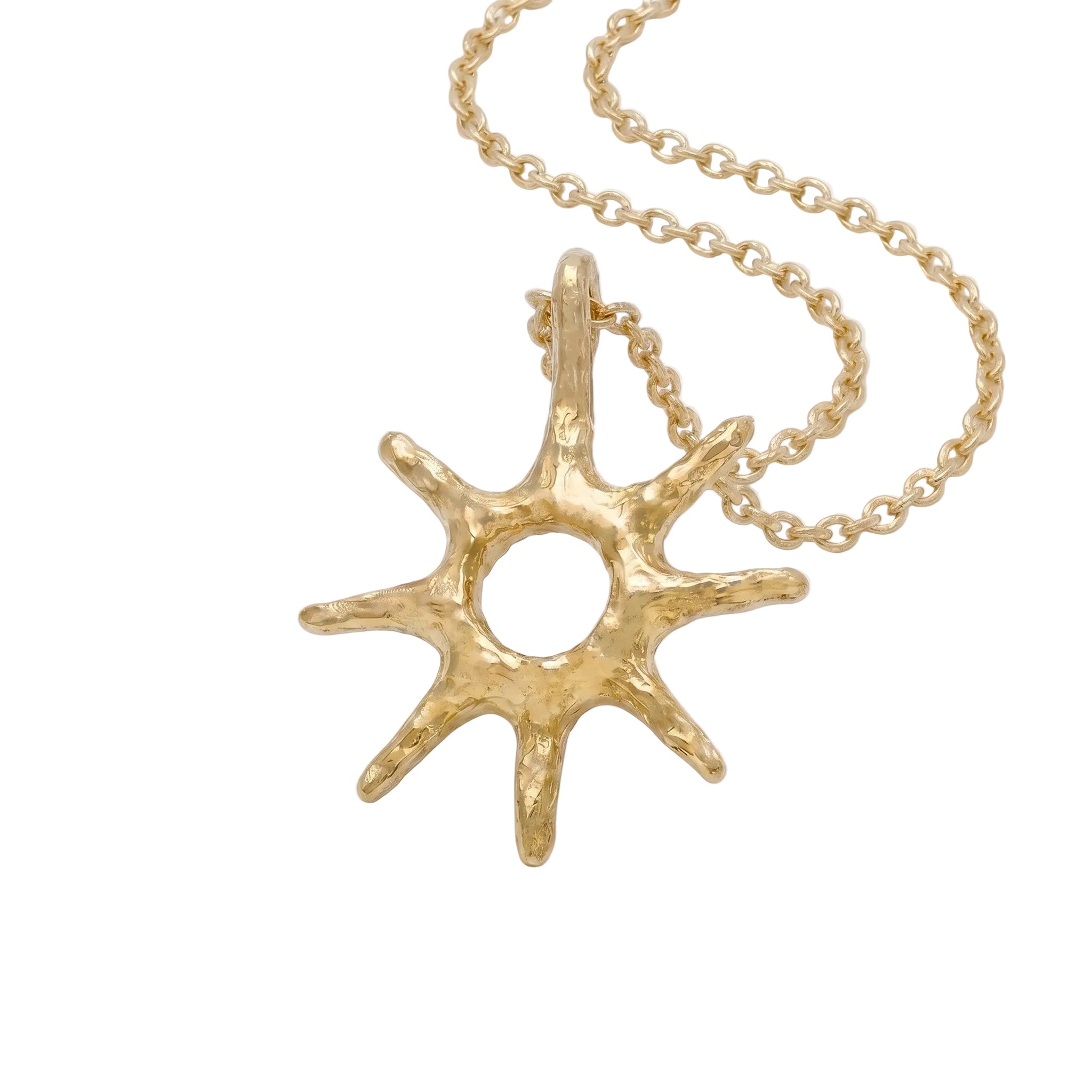  Colgante de oro con forma de estrella de ocho puntas y textura orgánica sobre un fondo blanco minimalista, mostrando detalles de la cadena.