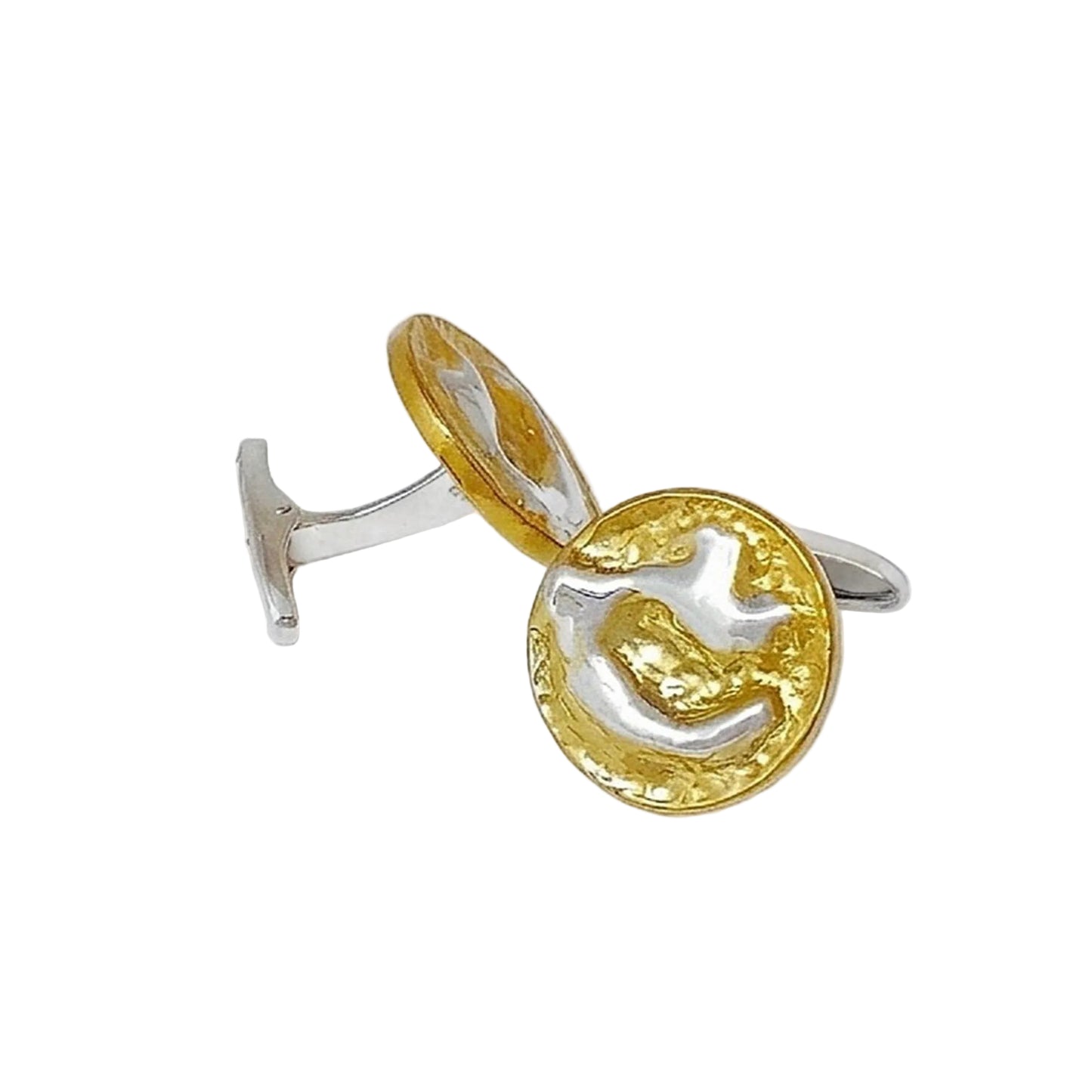 Primer plano de dos gemelos de joyería artesanales sobre un fondo blanco neutro. Los gemelos tienen una forma circular con relieve irregular que combina un baño de oro texturizado y detalles centrales en plata brillante.