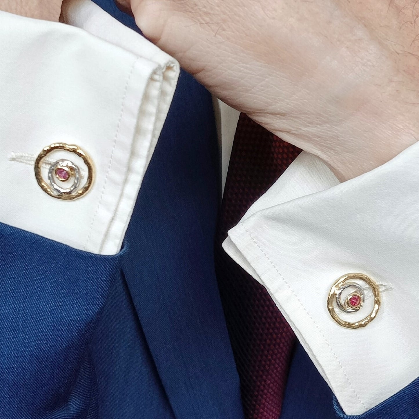 Gemelos artesanales de ondas en plata y oro vermeil con rubí rojo colocados en puños de camisa elegante