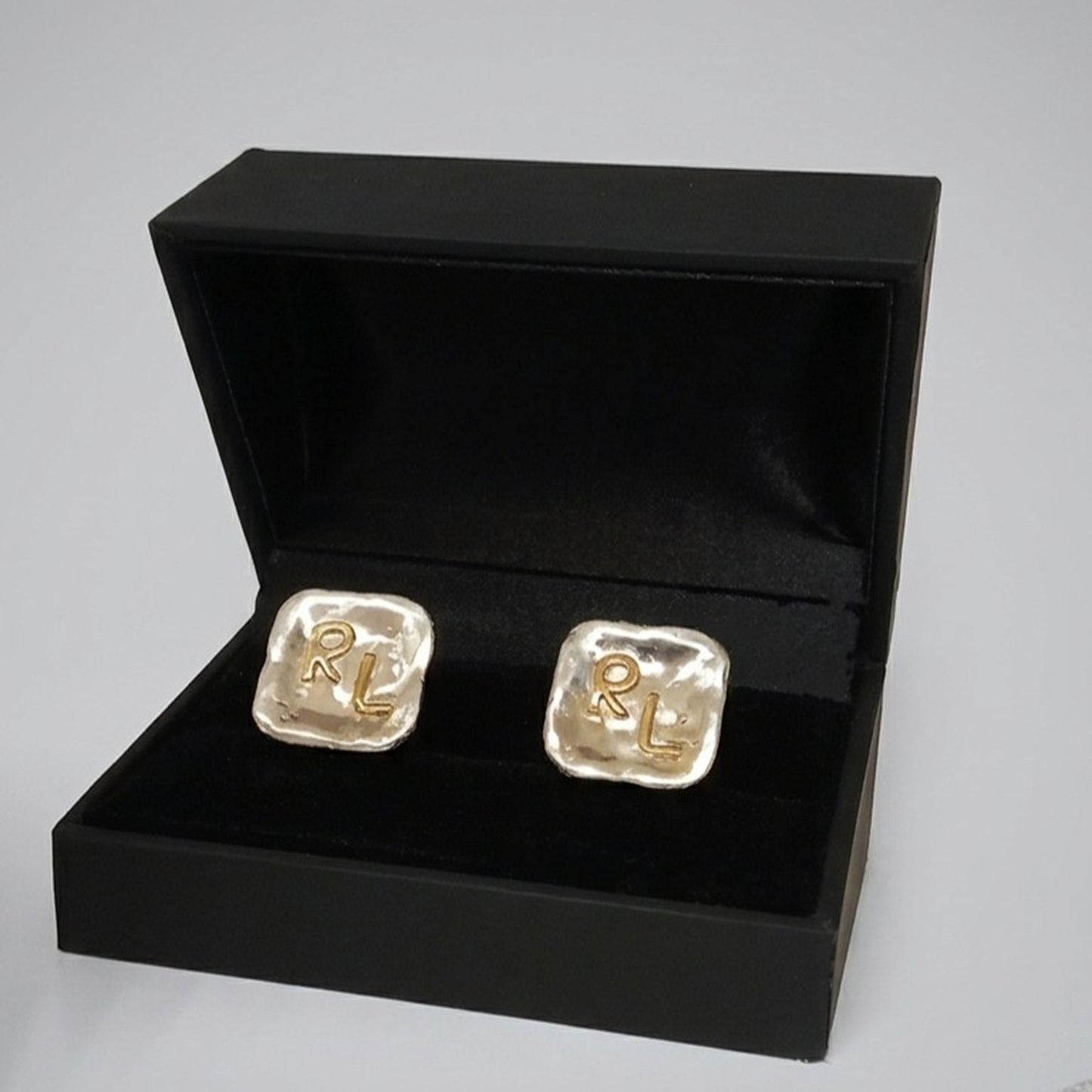 Pareja de gemelos personalizados de plata y oro de 18K con iniciales RL presentada en una caja de regalo negra.