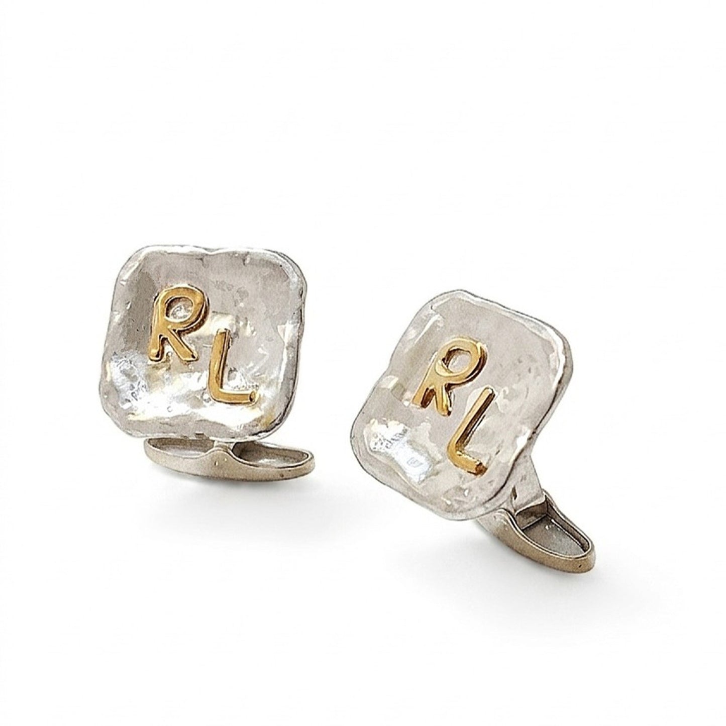 Pareja de gemelos personalizados de plata con iniciales RL en oro de 18K sobre una superficie orgánica y texturizada. 