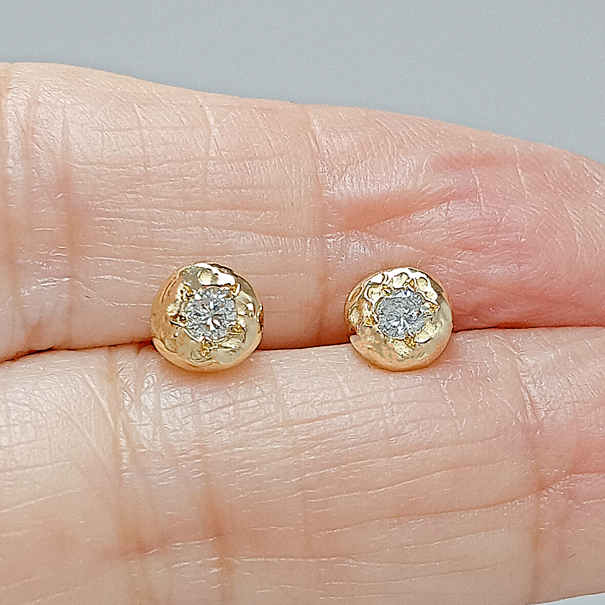 Detalle de un pendiente de oro de 18 k con diamante talla brillante